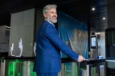 Ofiste. Memnun sakallı beyaz iş adamı ofise giriyor ve kararlı görünüyor.