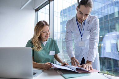 Hastanedeki erkek ve kadın doktorlar, tıp araştırmalarında işbirliği yapmak için teknolojiyi online danışmanlık için kullanıyorlar.