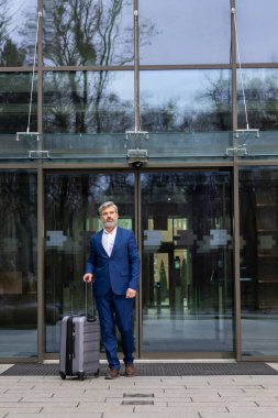 Geldik. Havalimanı girişinde zarif, olgun bir iş adamı var.