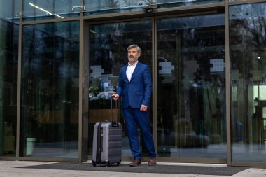 Geldik. Havalimanı girişinde zarif, olgun bir iş adamı var.