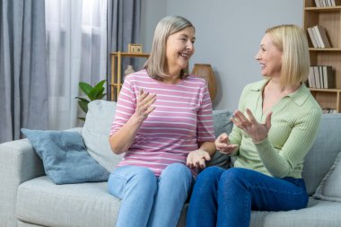 İletişim. İki kadın kanepede oturuyor ve güzel bir konuşma yapıyorlar.