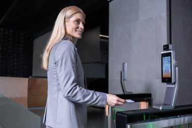 Güvenlik kontrolü. Uzun saçlı sarışın iş kadını iş merkezinde güvenlik kontrolünü geçiyor.