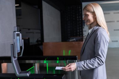 Güvenlik kontrolü. Uzun saçlı sarışın iş kadını iş merkezinde güvenlik kontrolünü geçiyor.