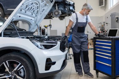 Teftiş aracının detaylarına bakan sakallı mühendis.