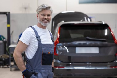 Otomotiv servis uzmanı garajda teftiş yapıyor ve aracı tamir ediyor