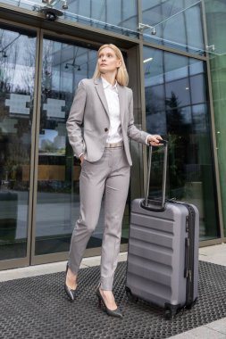Bavullu sarışın iş kadını şirket uçuşundan sonra yola çıkıyor.