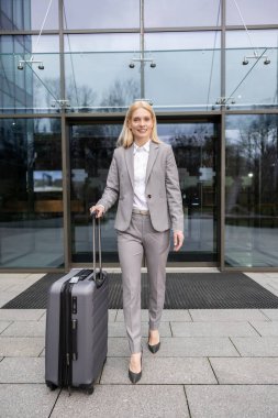 Kendine güveni tam bir iş kadını. Şehirdeki şirket gezisine giderken bavuluyla yürüyor.