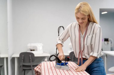 Ütü yapıyorum. Kadın moda tasarımcısı stüdyosunda ütü yapıyor.