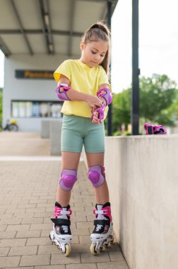 Patenci çocuk emniyet teçhizatını ayarlıyor stadyumda paten kaymaya hazırlanıyor.