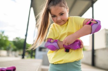 Patenci çocuk emniyet teçhizatını ayarlıyor stadyumda paten kaymaya hazırlanıyor.
