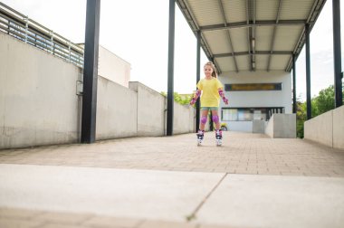 Kız buz pateni ustası. Yaz stadyumunda eğlenirken paten kayıyor.