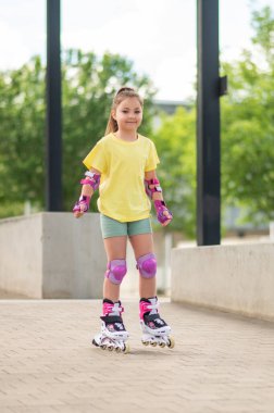 Kız buz pateni ustası. Yaz stadyumunda eğlenirken paten kayıyor.