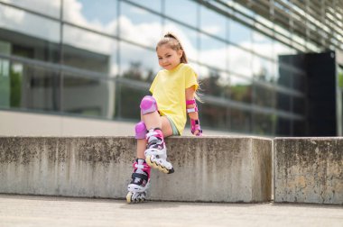 Paten kayan bir çocuk stadyumda paten kaydıktan sonra dinleniyor.