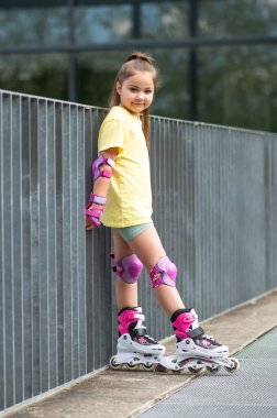 Küçük bayan patenci dışarıda paten eğitimi alıyor.