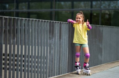 Küçük kız dışarıda kayak yapmaktan hoşlanıyor güneşli bir günde eğleniyor.