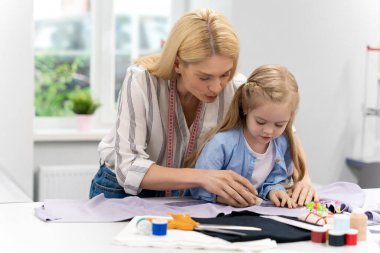 Tasarım stüdyosu. Anne ve çocuk bir tasarım stüdyosunda yeni bir model üzerinde çalışıyorlar.