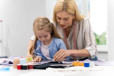 Tasarım stüdyosu. Anne ve çocuk bir tasarım stüdyosunda yeni bir model üzerinde çalışıyorlar.