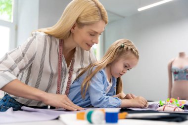 Tasarım stüdyosu. Anne ve çocuk bir tasarım stüdyosunda yeni bir model üzerinde çalışıyorlar.