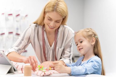 Birlikte çalışmak. Anne ve kızı tasarım stüdyosunda birlikte vakit geçiriyorlar ve memnun görünüyorlar.