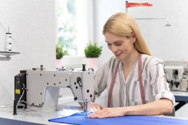 Dikiş dikiyorum Dikiş makinesinin başındaki sarışın, uzun saçlı beyaz kadın.