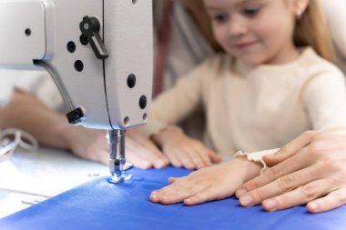 Yeni koleksiyon. Anne ve çocuk elbise tasarım stüdyosunda yeni bir koleksiyon üzerinde birlikte çalışıyorlar.