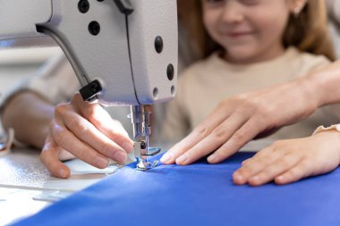 Dikiş dikiyorum Anne ve kızı dikiş makinesinde birlikte oturuyorlar ve meşgul görünüyorlar.