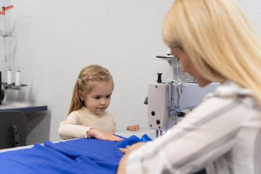 Kıyafet tasarımcısı stüdyosu. Sevimli küçük kız annesiyle bir tasarımcı stüdyosunda vakit geçiriyor.