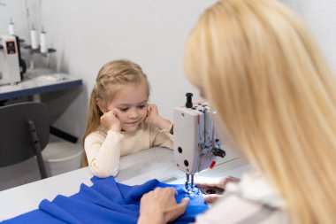 Kıyafet tasarımcısı stüdyosu. Sevimli küçük kız annesiyle bir tasarımcı stüdyosunda vakit geçiriyor.