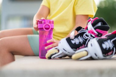 Paten kayan, su içen, susuz kalmayan yaz etkinliklerinin tadını çıkaran tanınmamış küçük kız.