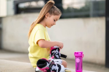 Genç bayan patenci dışarıda antrenman ve egzersiz için hazırlanıyor.