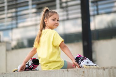 Dışarıda patenlerle oynayan enerjik bayan çocuk yaz tatilinin tadını çıkarıyor.