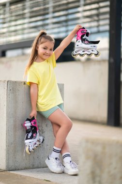 Aktif çocuk dışarıda paten kayıyor. Oyun saatlerinde ustalaşıyor. Paten kayıyor.