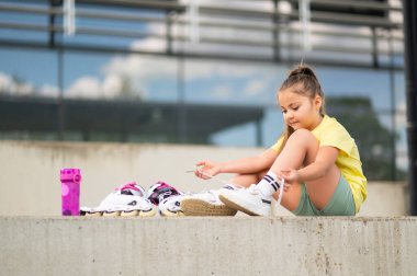 Paten giyen kadın çocuk stadyumda enerjik bir oyuna hazırlanıyor.