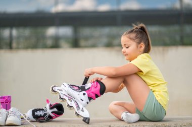 Paten giyen kadın çocuk stadyumda enerjik bir oyuna hazırlanıyor.