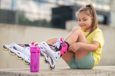 Paten kaymak için paten giyen genç bayan patenci.