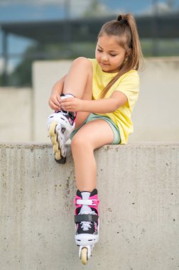 Paten kaymak için paten giyen genç bayan patenci.