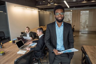 Ofiste. Zarif Afro-Amerikan iş adamı iş arkadaşlarıyla birlikte ofiste.