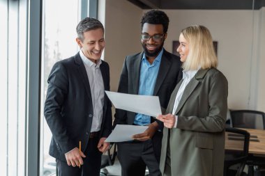 İş adamları. Ofiste memnun ve kendinden emin bir grup insan var.