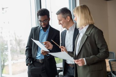 İş adamları. Ofiste memnun ve kendinden emin bir grup insan var.