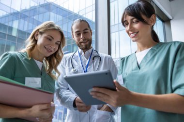 Doktorlar iş başında. Genç doktorlardan oluşan bir ekip bir şey tartışıyor ve ilgili ve ilgili görünüyor.