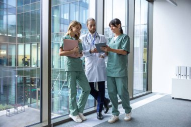 Klinikte. Laboratuvar önlüklü bir grup genç doktor klinik koridorunda yürüyor ve konuşuyorlar.