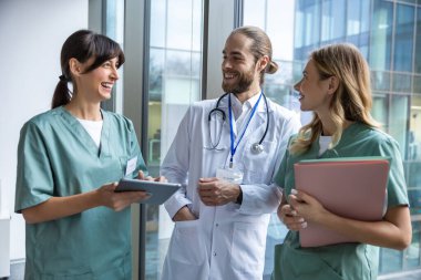 Klinikte. Laboratuvar önlüklü bir grup genç doktor klinik koridorunda yürüyor ve konuşuyorlar.