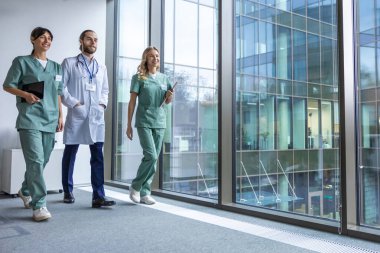 Bir grup doktor. Hastane koridorunda laboratuvar önlüklü genç terapistler.