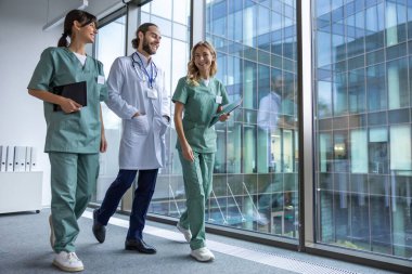 Bir grup doktor. Hastane koridorunda laboratuvar önlüklü genç terapistler.