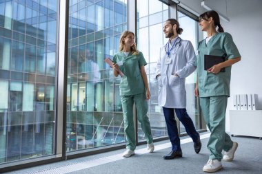 Bir grup doktor. Hastane koridorunda laboratuvar önlüklü genç terapistler.