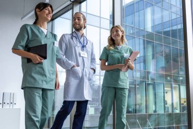 Bir grup doktor. Hastane koridorunda laboratuvar önlüklü genç terapistler.