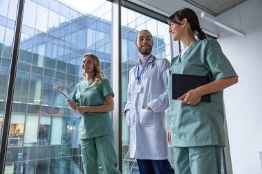 Bir grup doktor. Hastane koridorunda laboratuvar önlüklü genç terapistler.