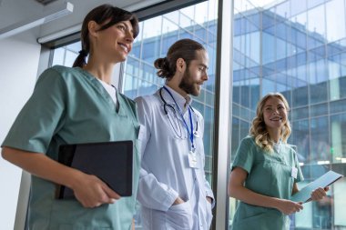 Bir grup doktor. Hastane koridorunda laboratuvar önlüklü genç terapistler.
