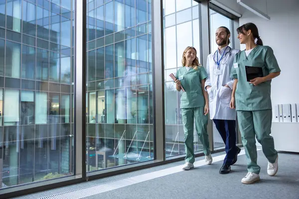 Klinikte. Laboratuvar önlüklü bir grup genç doktor klinik koridorunda yürüyor ve konuşuyorlar.