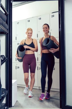 Antrenmandan önce. Spor salonunda paspaslı, taş gibi genç kadınlar.